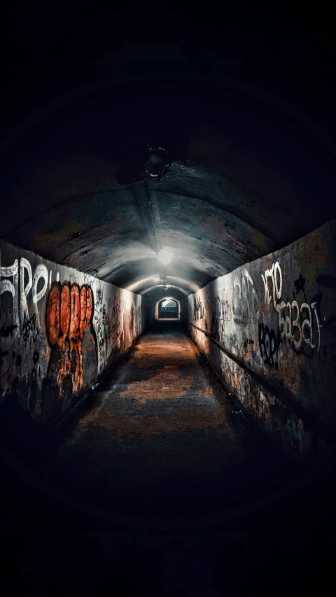 an empty tunnel with graffiti on the walls