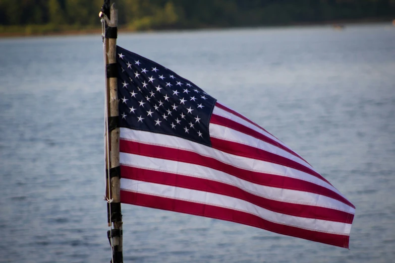 a red white and blue flag by the water