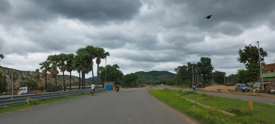 this is an empty road during the day with clouds in the sky