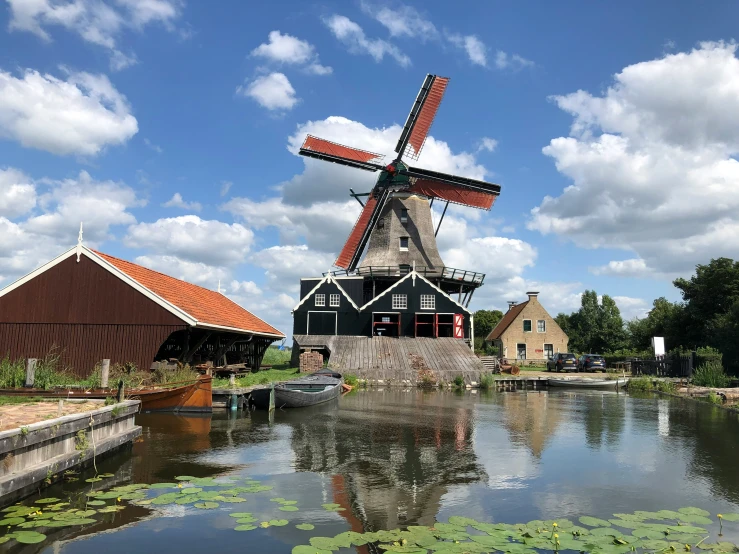 an old windmill sits in front of a river