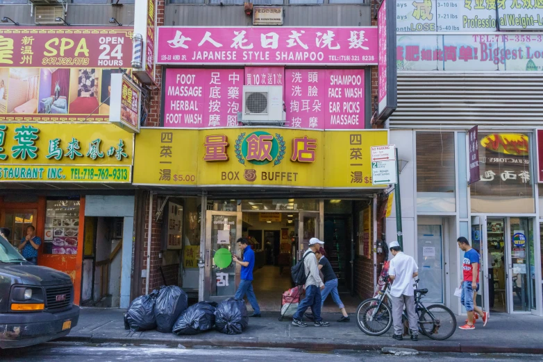 there are people walking in the street near some stores