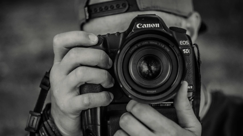 a man is holding up his camera with both hands