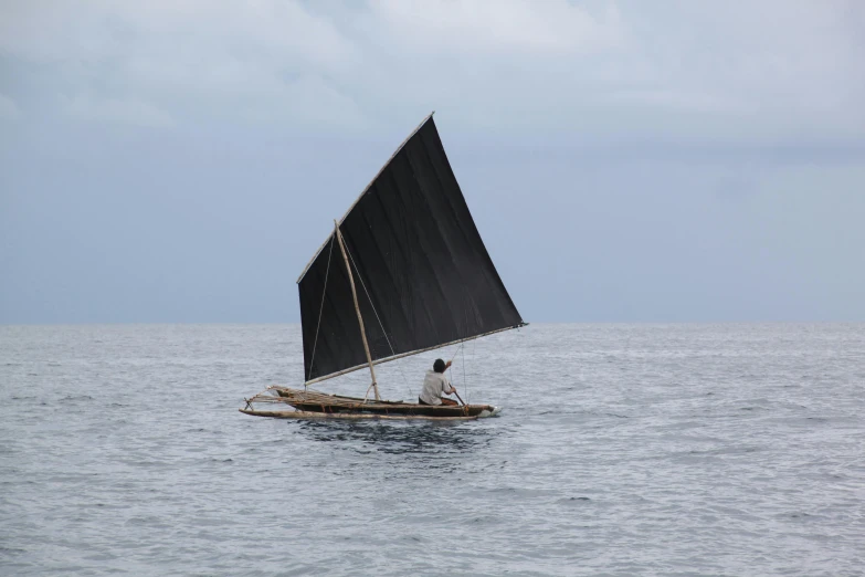 a man riding a sail boat on the water