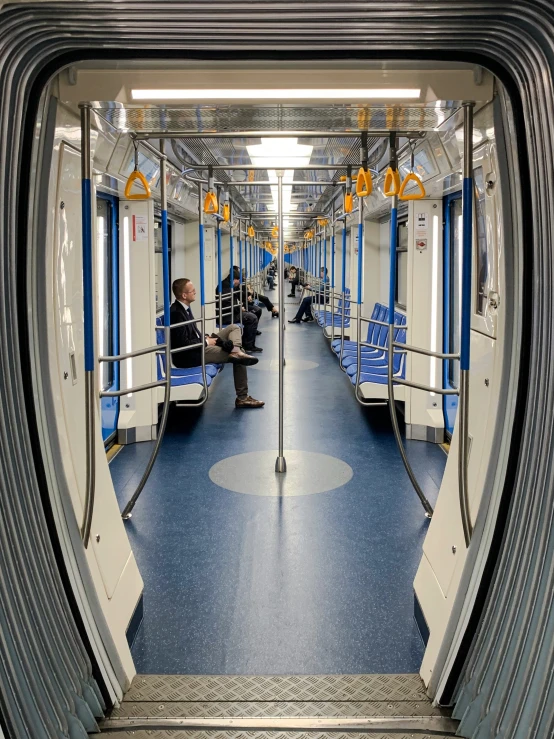 two people sitting on the seats inside of a public transit train