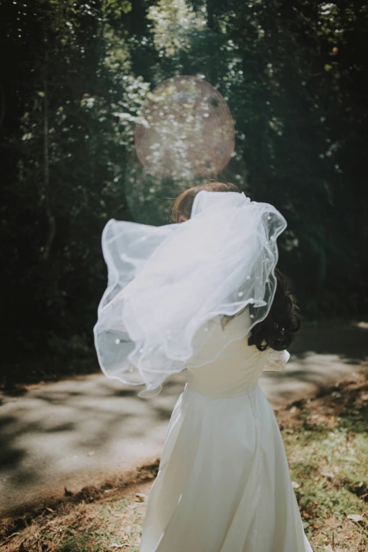 a woman in a white wedding dress with her arms around her back