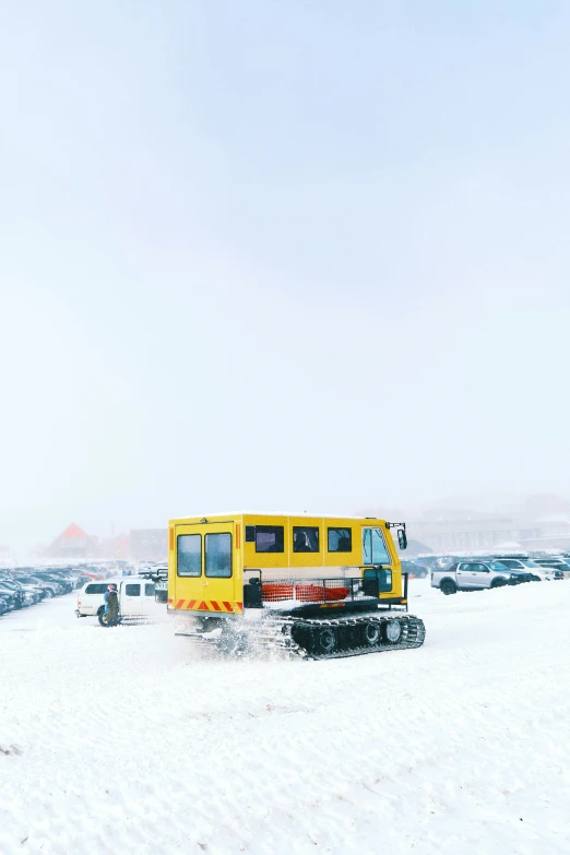 the large, yellow work vehicle is parked in the snow