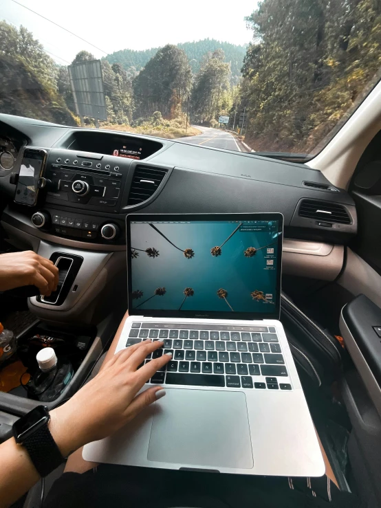 a person working on a laptop in their car