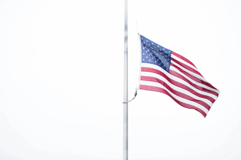 an american flag flies in the wind on a pole