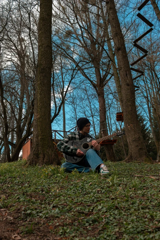 a man is sitting by himself with a guitar