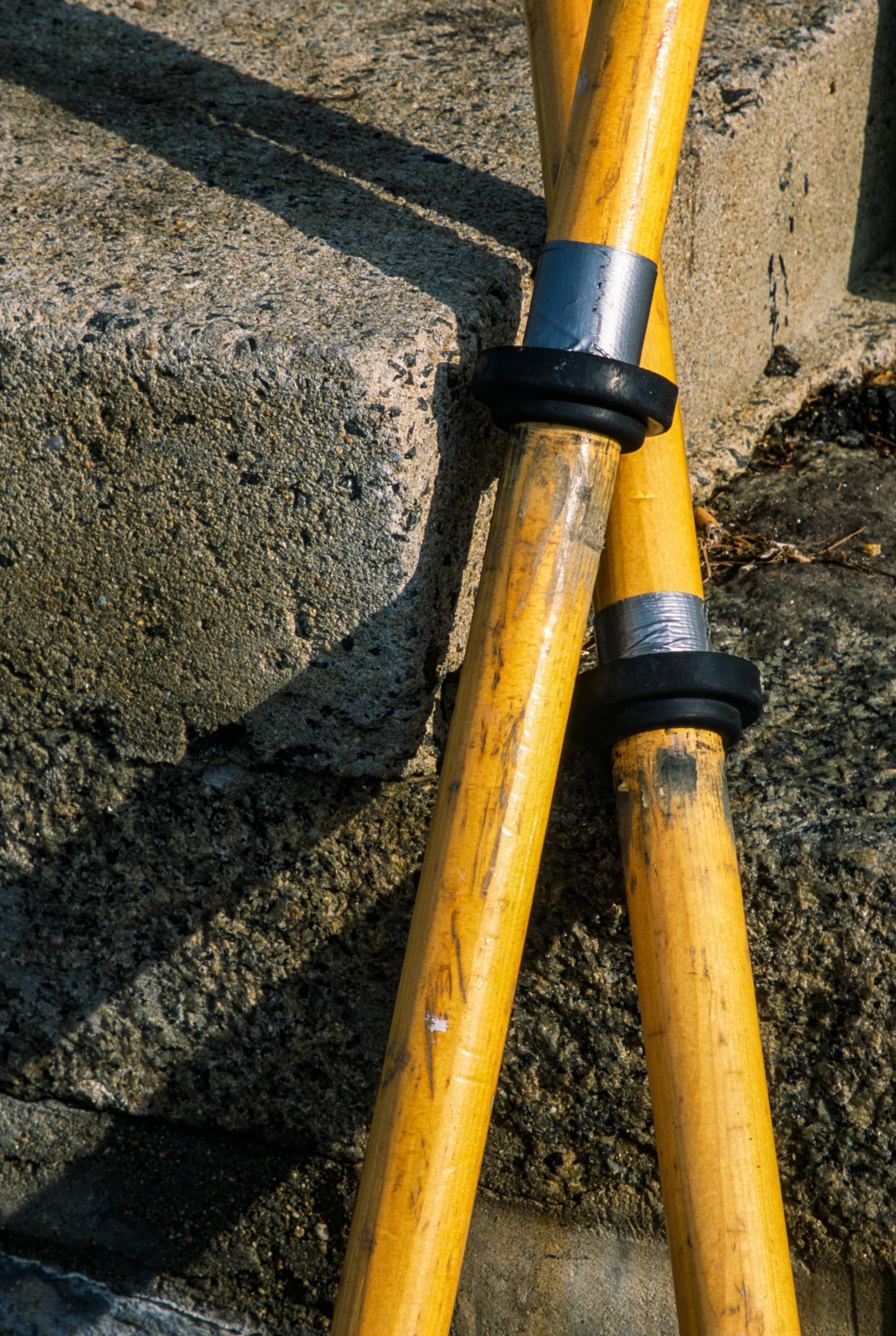 two wood poles are laying on concrete by some steps