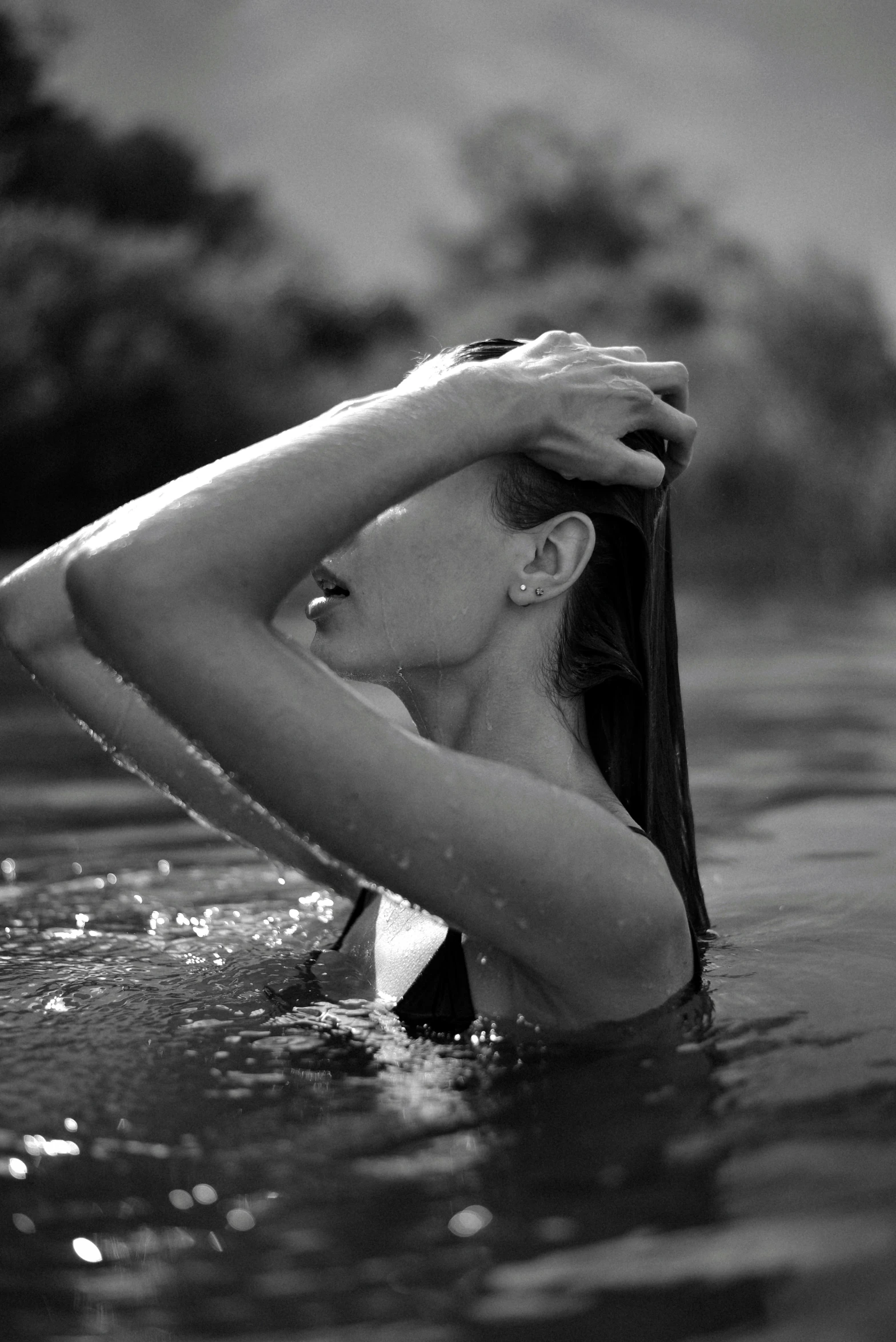 a woman standing in a pool of water with her hand on her head