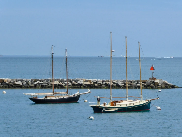 two sailboats docked in front of a pier