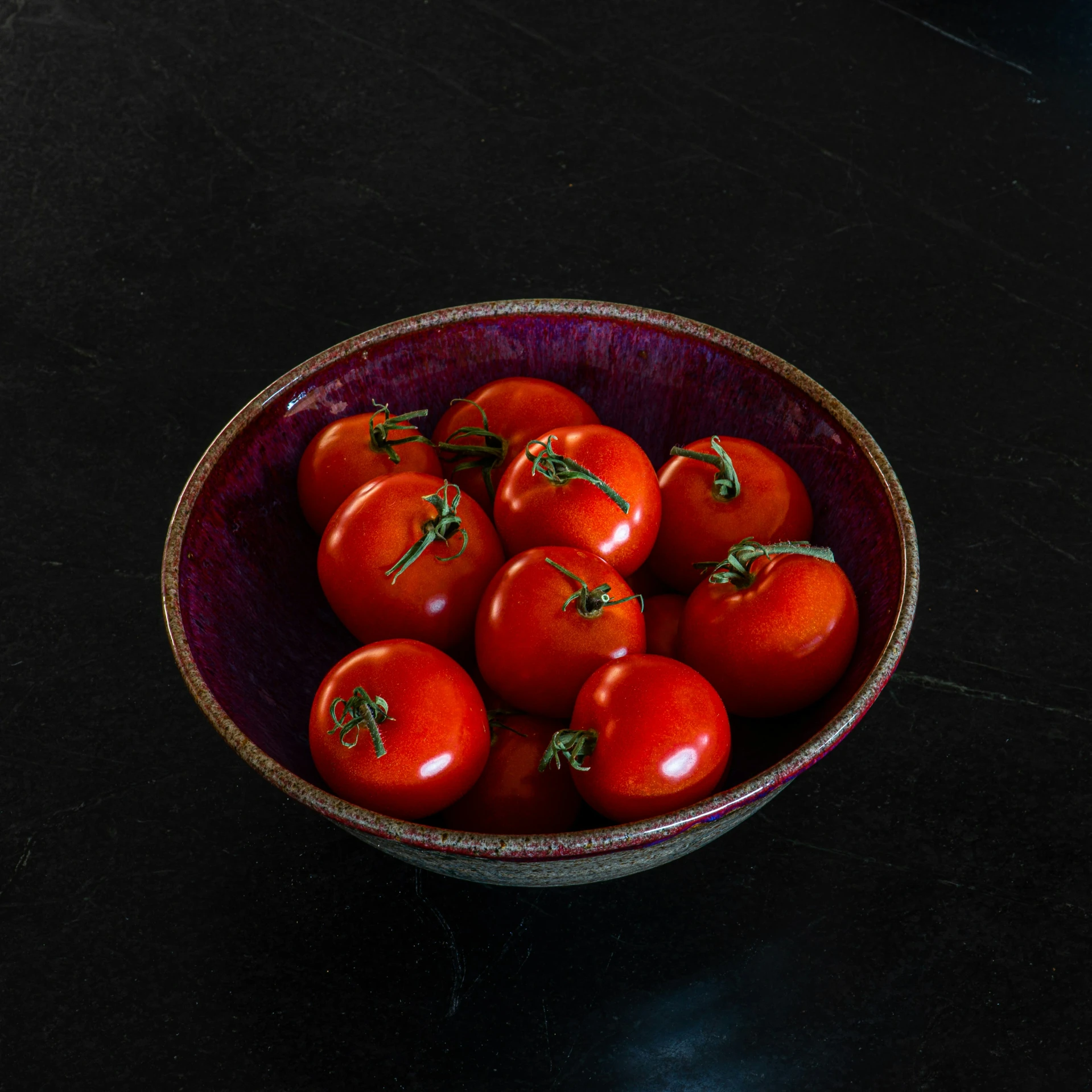 a bowl of some small tomatoes on a table