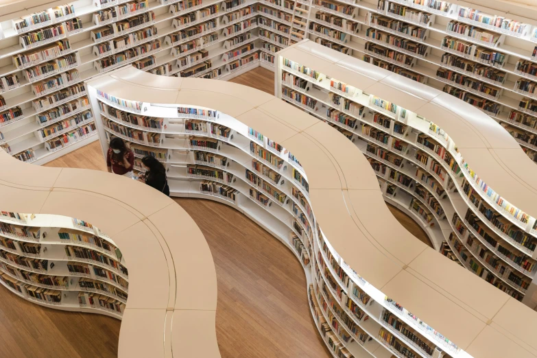 people who are sitting in the middle of two bookshelves