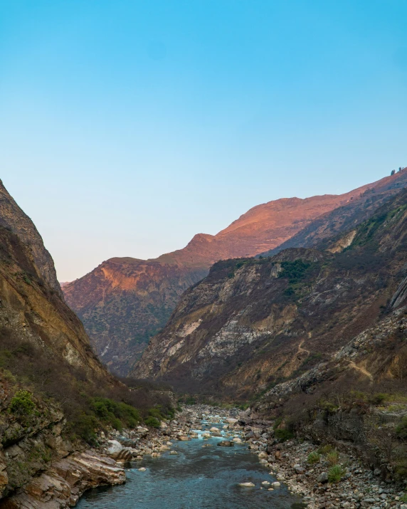 a valley with mountains and a river in front