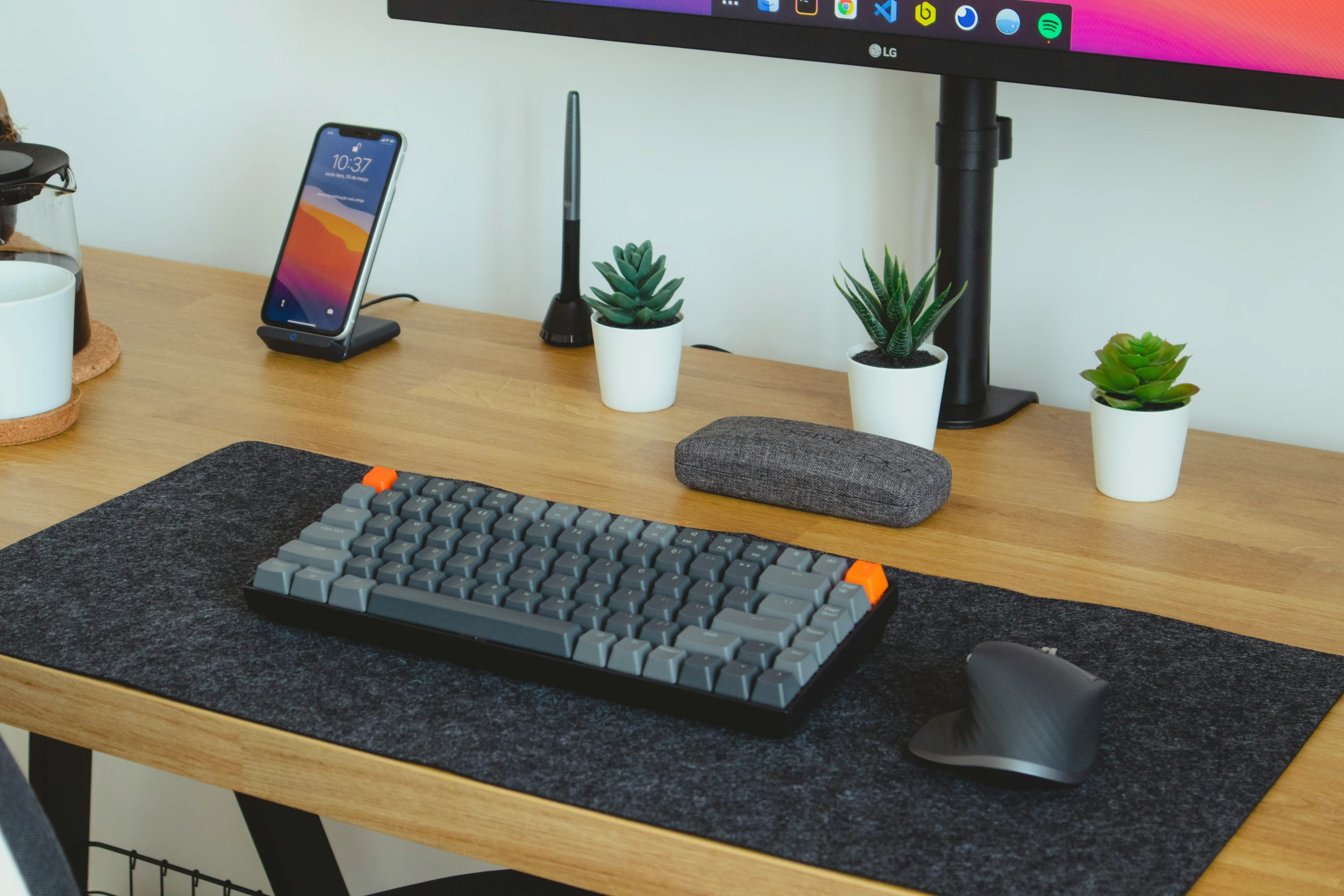 a computer with an apple mac keyboard and a mousepad on a desk