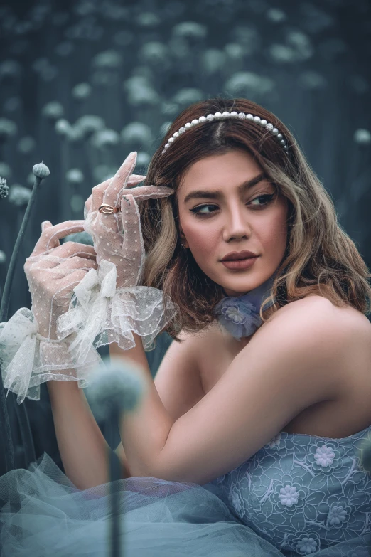 a woman wearing gloves in front of flowers