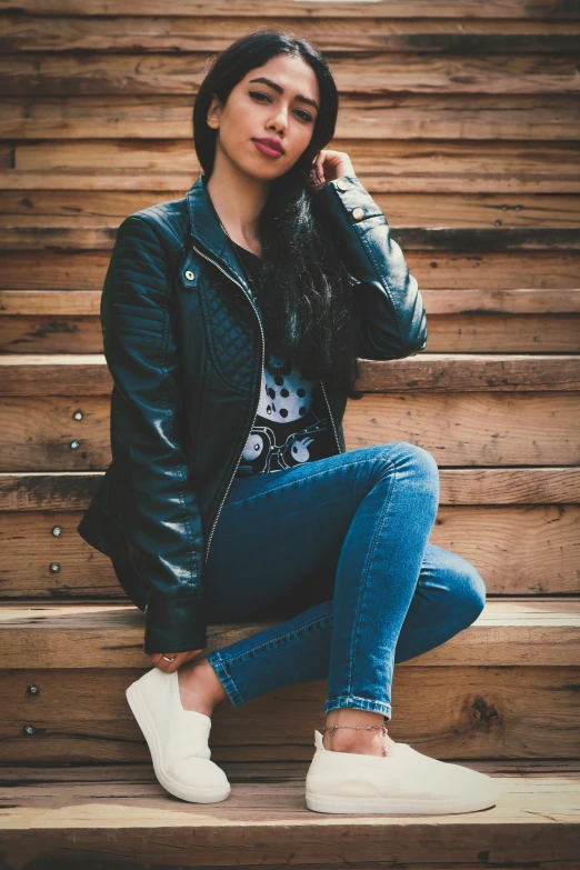 a beautiful young woman sitting on some steps