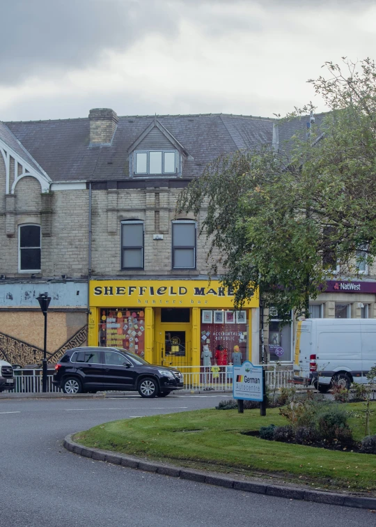 the city street has a yellow store on the corner