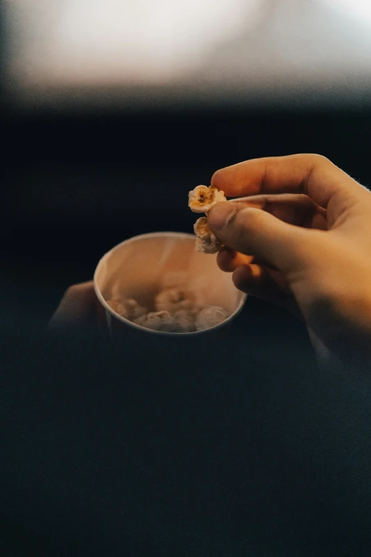 a person holding a bowl with flowers in it