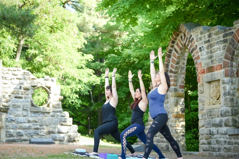 three people in a line doing yoga poses