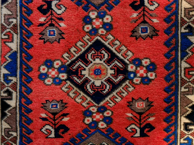 a closeup of an oriental rug with diamonds and stripes