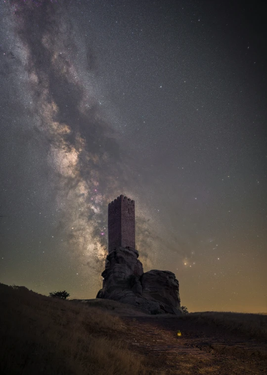 the night sky with some stars and a tower