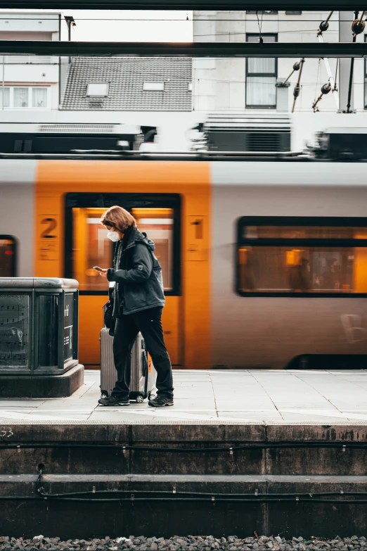 a man standing at a station with a suitcase