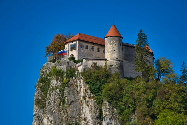 an old castle that is on a rock above a lake