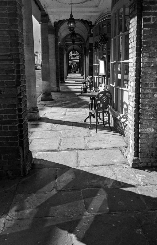 an old looking building has tables and chairs on it