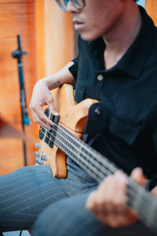 a man in glasses and black shirt playing an instrument