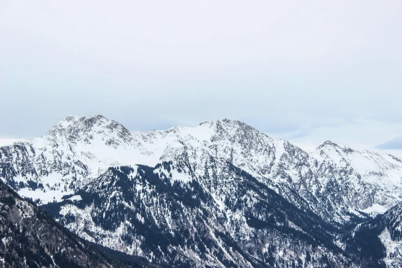 snow covered mountains with one plane on the top