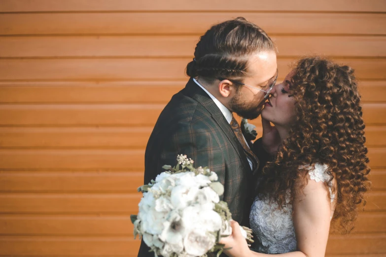 a beautiful woman kissing a man with a bouquet of flowers