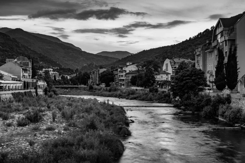 black and white pograph of a small river running between two buildings