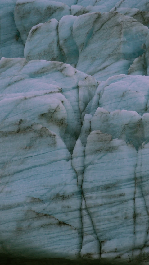 a close - up of some icy rocks with the snow falling off the top of it