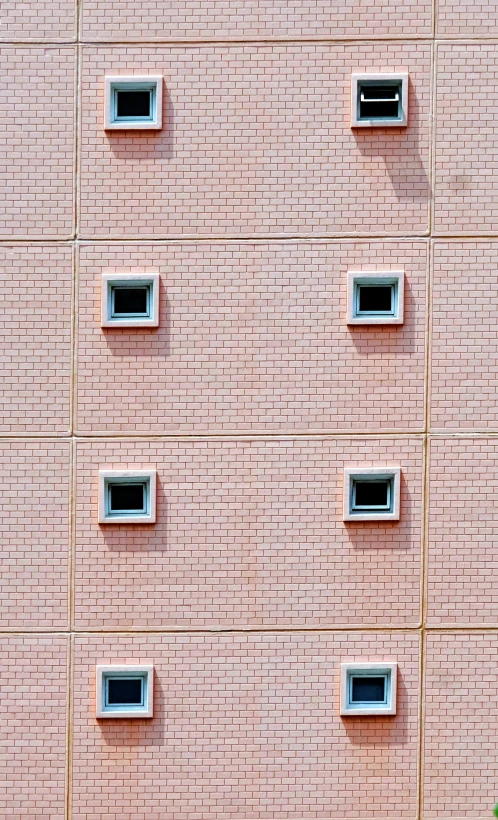 three black cats are sleeping on the ledge of a brick building