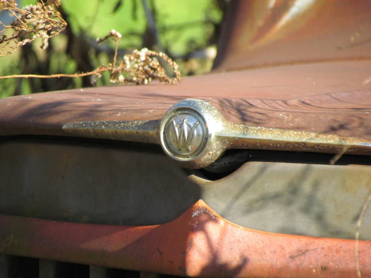 an old metal handle on the front of a rusty vehicle