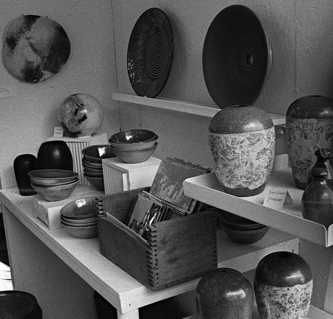 an old pograph of vases and other objects on shelves