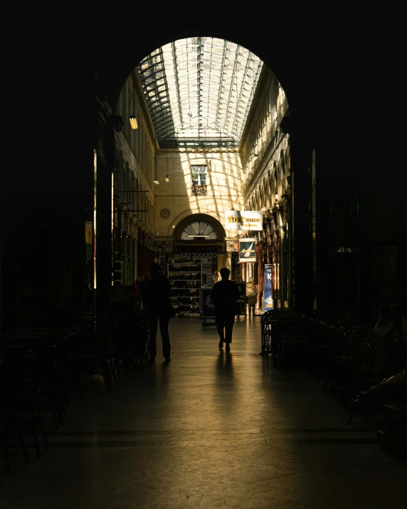 an empty, dark hallway with light on the ceiling and dark floors