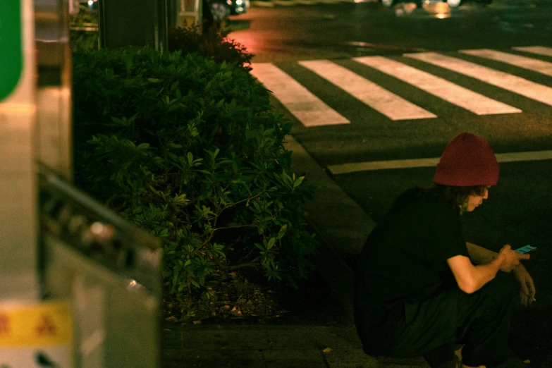 a woman in a red hat looking down at her phone