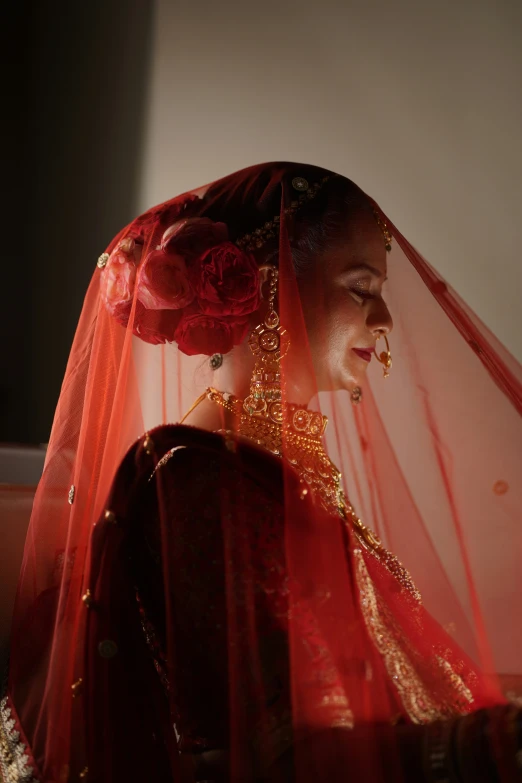 the bride is in red wedding outfit with red veil