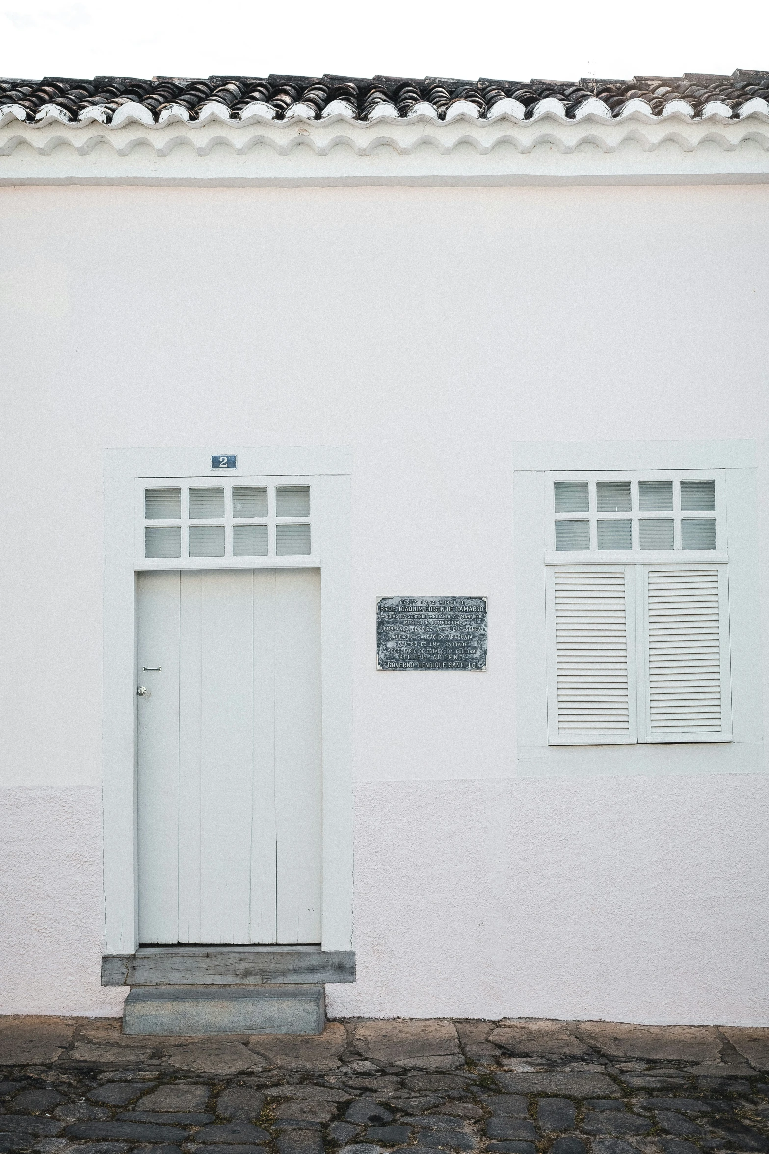 a white house with an open door and shutters