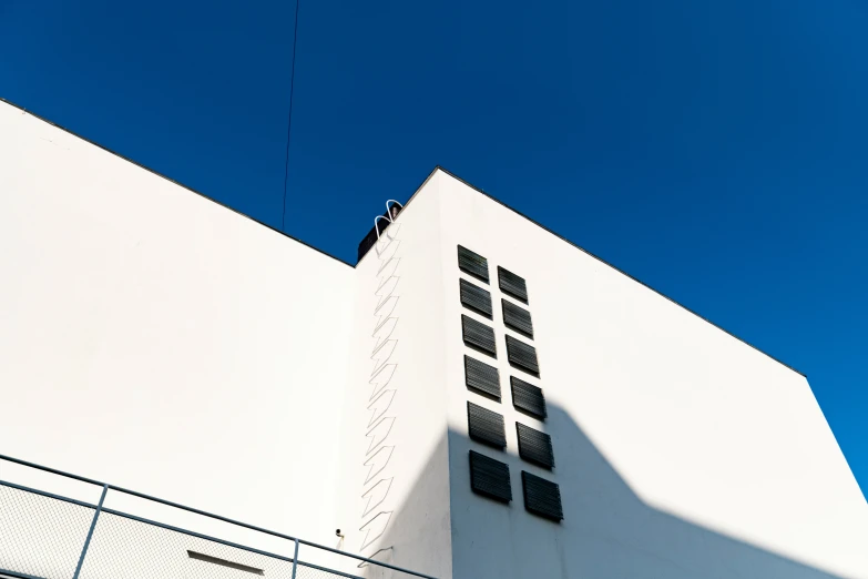 a building against a blue sky with a small kite in the sky above