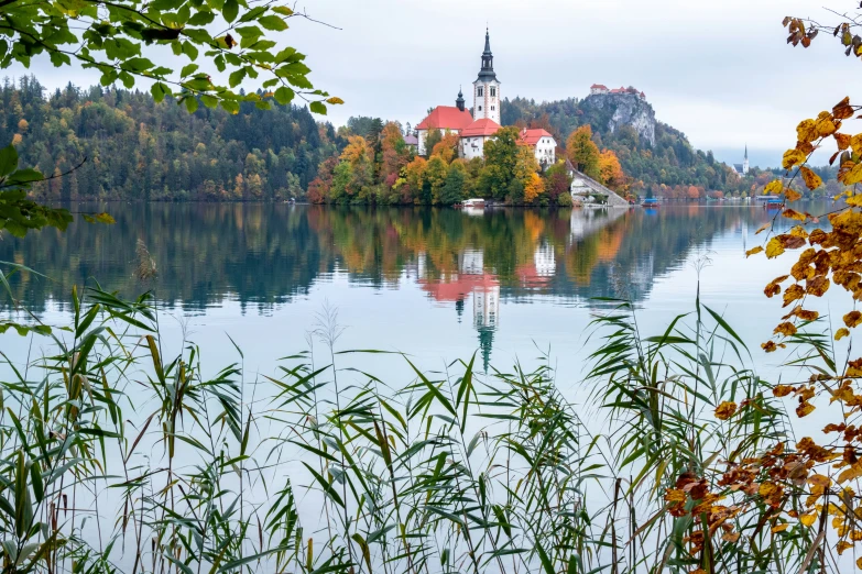 a church sitting on a small island next to the lake