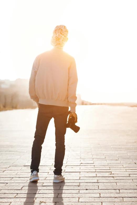 a person in a jacket standing on a brick walkway