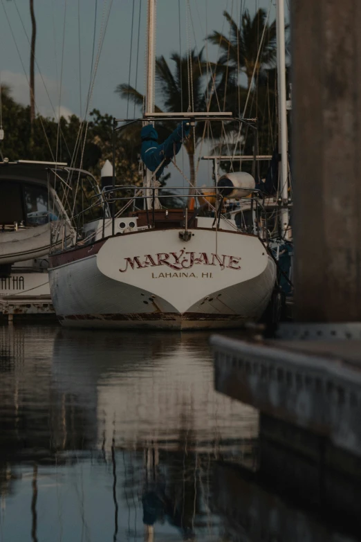 sailboats at dock on tropical waterway with buildings in background