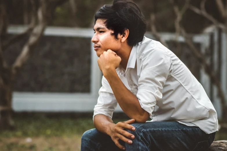 a man is squatting down looking out