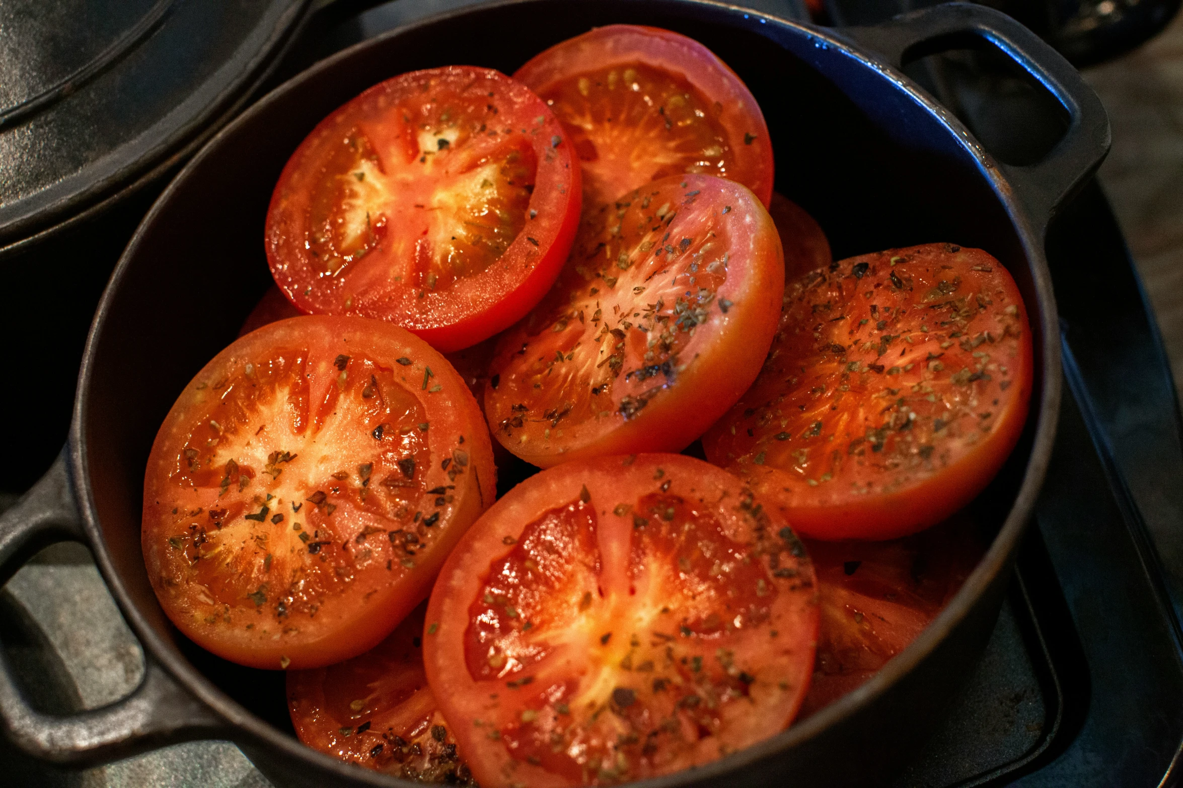 the tomato halves are fried in a cast iron pan