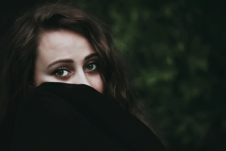 a close - up of a woman with her eyes closed, covering her face