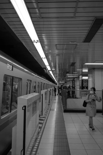 a subway station with people standing by a subway train